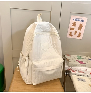 Detail of off-white wrinkled nylon backpack texture with drawstring side pockets