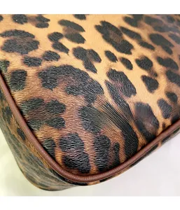 Close-up of leopard print textured synthetic leather with brown piping detail on travel bag
