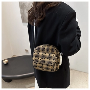 Detail showing checkered canvas crossbody bag with heart print and white tassel zip