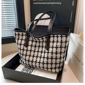 Primo piano della borsa tote in tweed a scacchi bianco e nero in un moderno contesto urbano