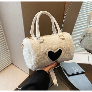 Detailansicht der weißen Teddy-Tasche mit schwarzem Herz-Patch und goldenen Beschlägen