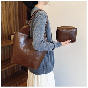 Detailed view of brown leather tote bag set with two pieces shown by a model