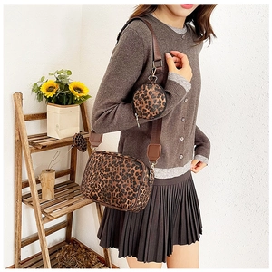 Detail view of leopard print crossbody camera bag set with round mini coin purse on strap