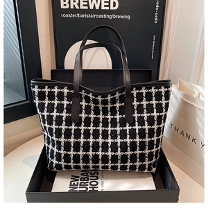Vista dettagliata della borsa tote in tweed a scacchi bianco e nero in scatola regalo