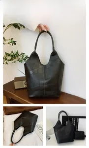 Detail of black patchwork tote bag with matching zippered pouch and textured geometry