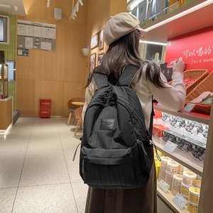 Minimalist black textured backpack for school and travel worn by a female model