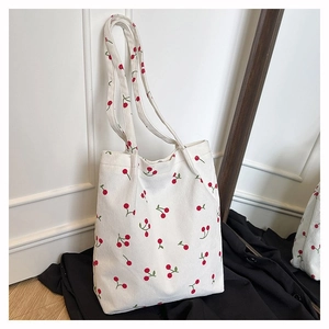 Dettaglio della borsa tote in velluto a coste con stampe di ciliegie rosse e texture