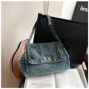 Detail view of the blue denim shoulder bag showing the silver metal twist-lock and chain strap