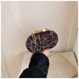 Detailweergave van luipaardprint clutch met gouden striksluiting en metalen ketting