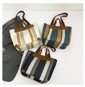 Détail de sacs fourre-tout en toile rayée avec poignées en cuir en plusieurs combinaisons de couleurs