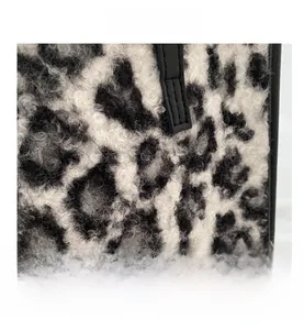 Vue détaillée de la texture en fausse fourrure léopard noir et blanc avec sangle en cuir