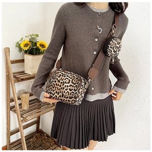 Detail of leopard print crossbody bag with detachable round coin purse on wide strap