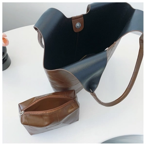 Detail view of the deep brown embossed leather tote and its matching zipper pouch insert
