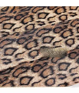 Close-up of leopard print fabric texture featuring dark brown and black spotted patterns