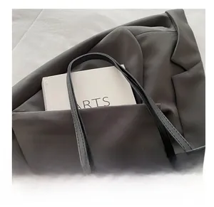 Détail du sac cabas en peluche imprimé léopard avec de fines anses en cuir noir souple