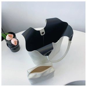 Detail view of white textured tote and matching pouch set with black contrast lining