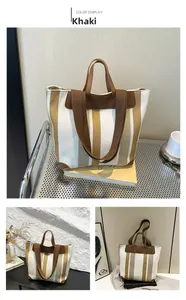 Détail du sac cabas à rayures kaki avec anses en cuir et large bandoulière ajustable