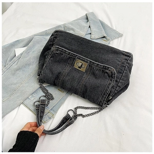 Close-up of black washed denim shoulder bag with retro metal twist lock and chain strap