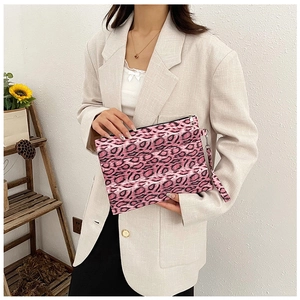 Pink leopard print envelope clutch bag with textured fabric and stylish wristlet strap