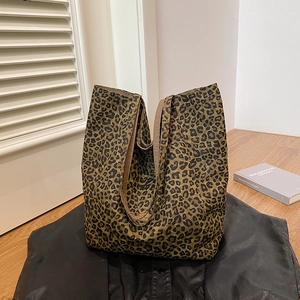 Detailed view of the leopard print canvas tote bag on a stylish leather jacket