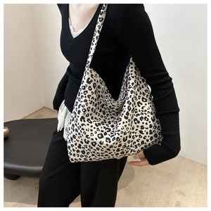 Detail van een zwart-witte hobo-tas met luipaardprint en een brede schouderband