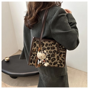 Détail du sac cabas léopard avec texture en fourrure et anses en cuir marron élégantes