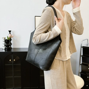 Vintage black textured tote bag with geometric pattern in a stylish interior setting