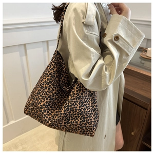 Detail van de grote tote bag met luipaardprint gedragen met een beige trenchcoat