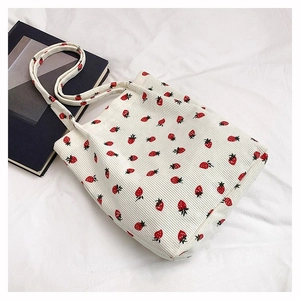 Dettaglio borsa shopper in velluto a coste bianco con simpatiche stampe di fragole