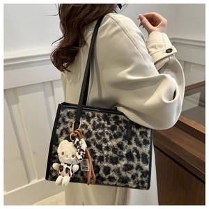 Détail du sac cabas en fausse fourrure léopard avec charm peluche et lanières en cuir
