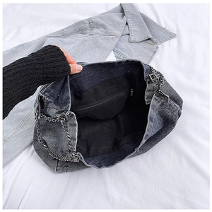 Macro view of the spacious inner compartment with zip pocket and dark chain strap