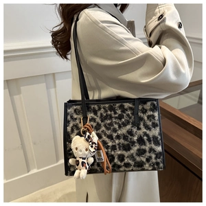 Détail du grand sac cabas en peluche léopard gris avec un pendentif mignon