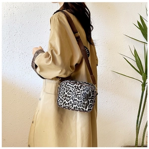 Chic leopard print crossbody camera bag shown on a model with an adjustable brown strap