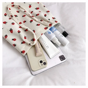 Dettaglio della borsa tote in velluto a coste bianco con stampe di fragole rosse e verdi