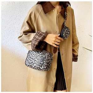 Detail view of leopard print crossbody bag set with wide brown shoulder strap on model