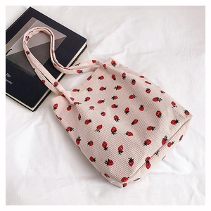 Dettaglio borsa tote in velluto rosa con stampa di fragole e doppie tracolle piatte