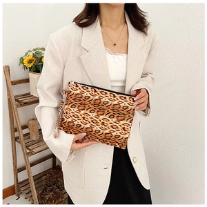 Close-up of leopard print clutch bag with black zipper and detachable wrist strap
