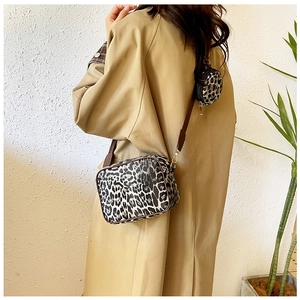 Crossbody leopard print handbag set with matching coin purse worn on trench coat
