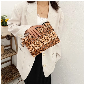 Detail view of stylish leopard print clutch bag with zipper and silver metal hook ring