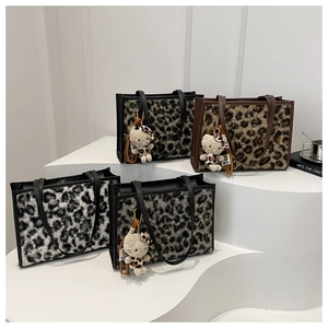 Détail des sacs cabas en peluche imprimé léopard avec des textures douces et charms
