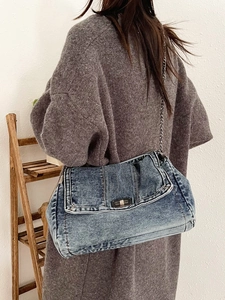 Retro denim shoulder bag with metal chain strap worn by model against minimalist background