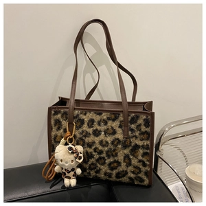 Détail du grand cabas en peluche léopard avec anses en cuir et pendentif mignon