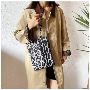 Detailed macro view of black and white leopard print fabric on a stylish wristlet bag