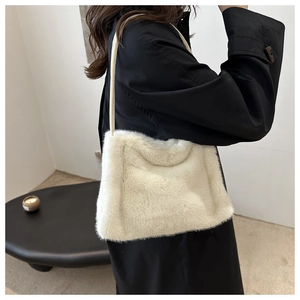 Detailaufnahme der weichen weißen Kunstfell-Textur einer modischen Herbst-Winter-Tasche