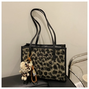 Détail du sac fourre-tout en peluche léopard avec anses en similicuir noir et poupée