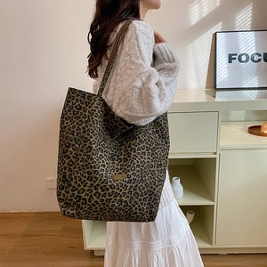 Detailed shoulder view of a large leopard print canvas tote bag with olive green base