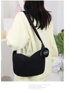 Detail of black corduroy crescent bag with a matching coin purse on the shoulder strap
