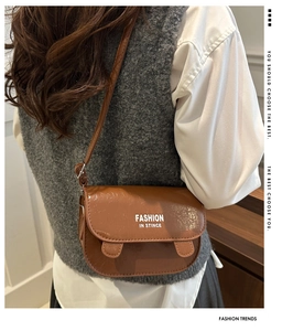 Close-up of brown faux leather texture with Fashion In Stince text on a small square bag