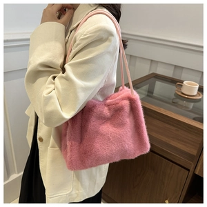 Detailansicht einer rosa Plüsch-Schultertasche, getragen von einem Model im modernen Raum