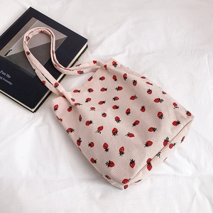 Dettaglio della borsa tote in velluto a coste rosa con motivo fragola su base bianca